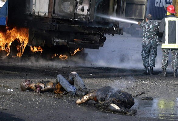 Quote A member of the Lebanese Red Cross walks past a badly burnt body in Beirut's port, which was targeted by Israeli warplanes-2 Unquote